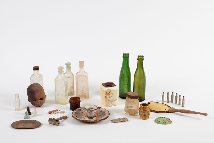 A collection of old bottles, containers and other items found in the ground.